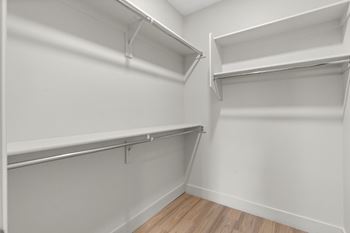 Spacious walk-in closets with custom wood shelving